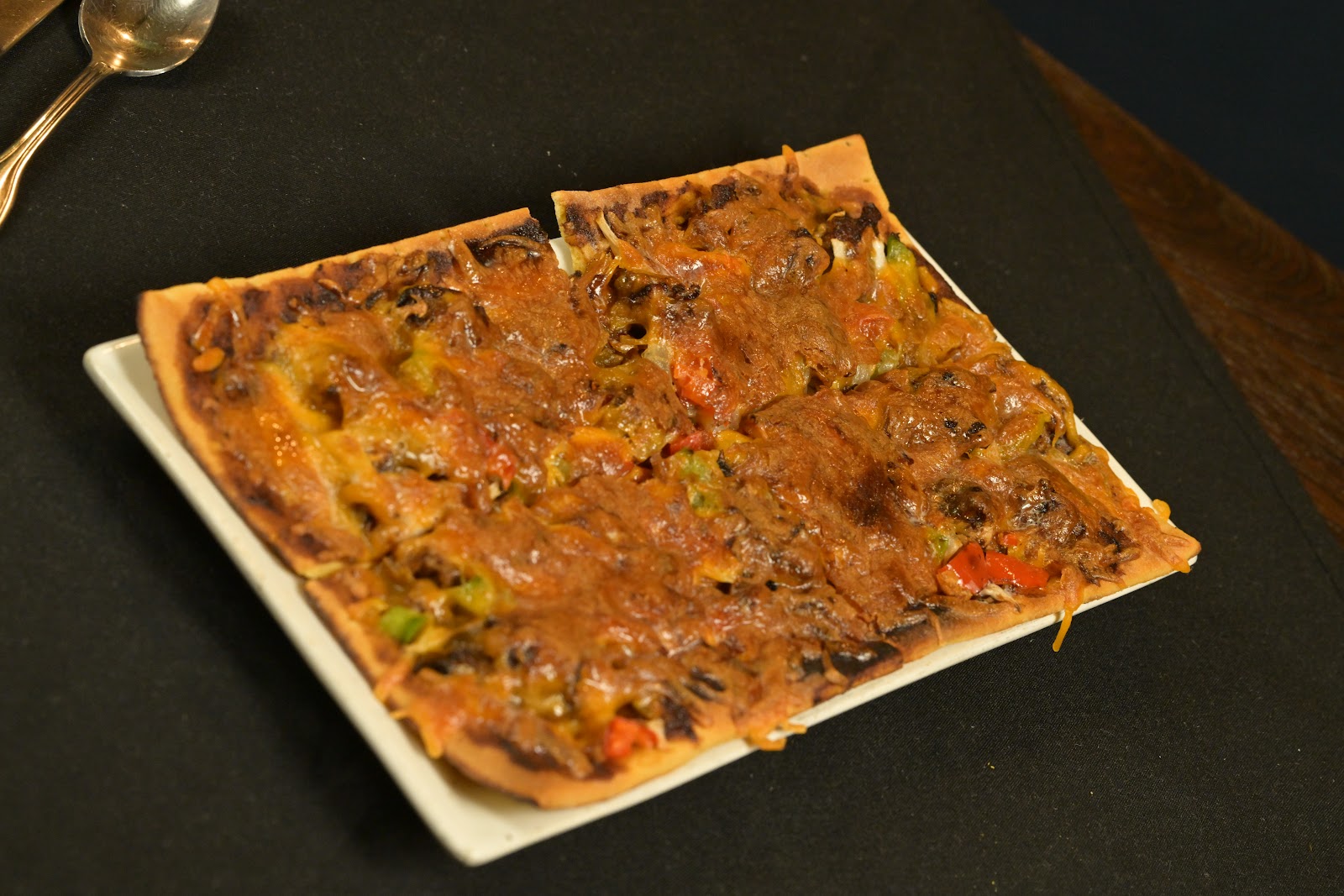 Loaded flatbread topped with peppers and seasoned meat