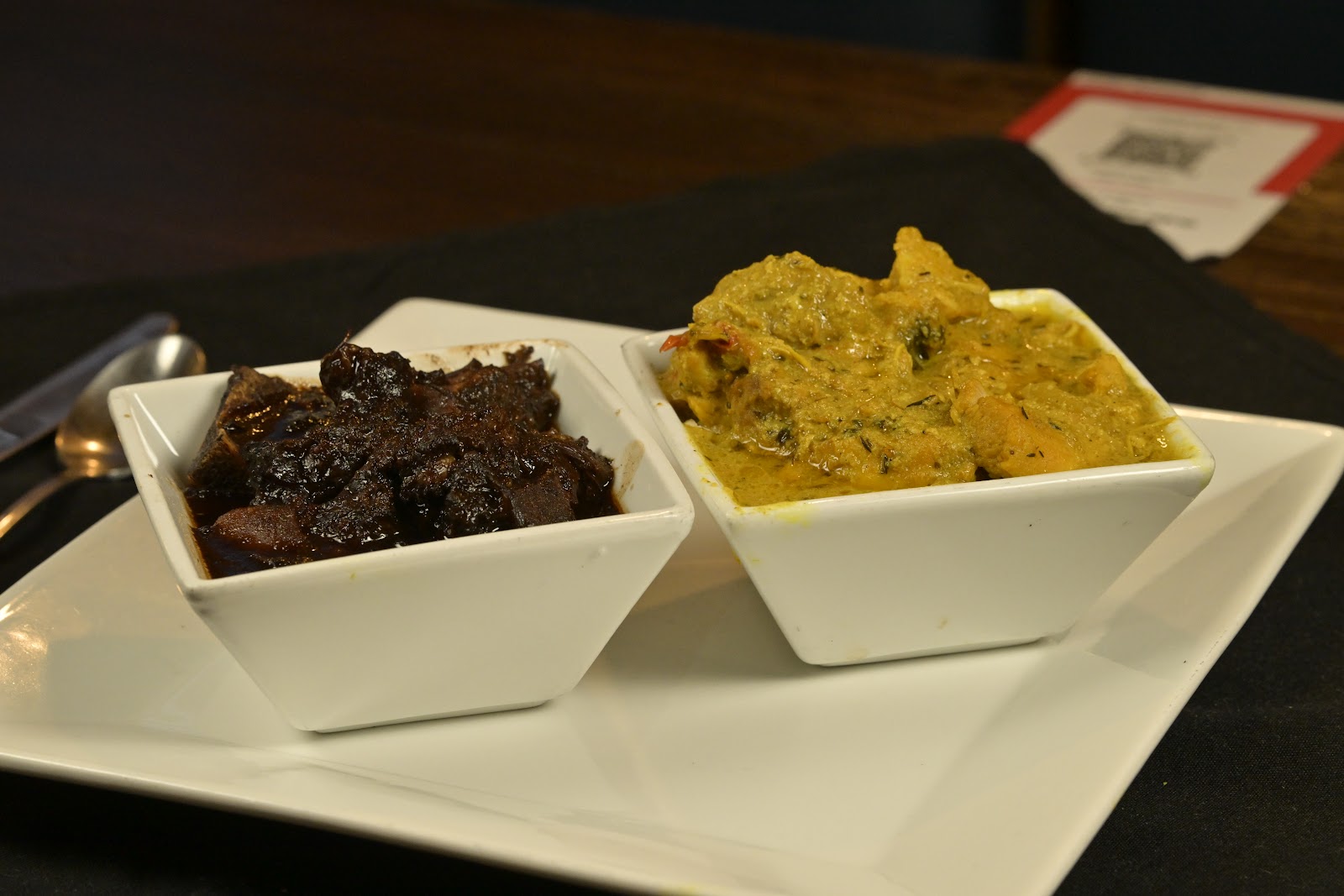 Oxtail stew served beside a curry in white square bowls