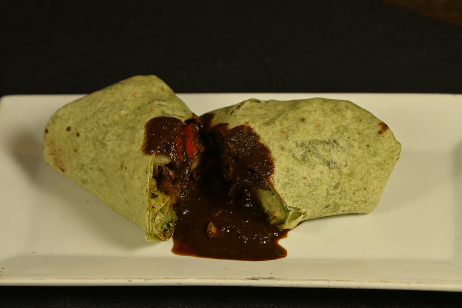 Spinach wrap filled with rich stewed meat