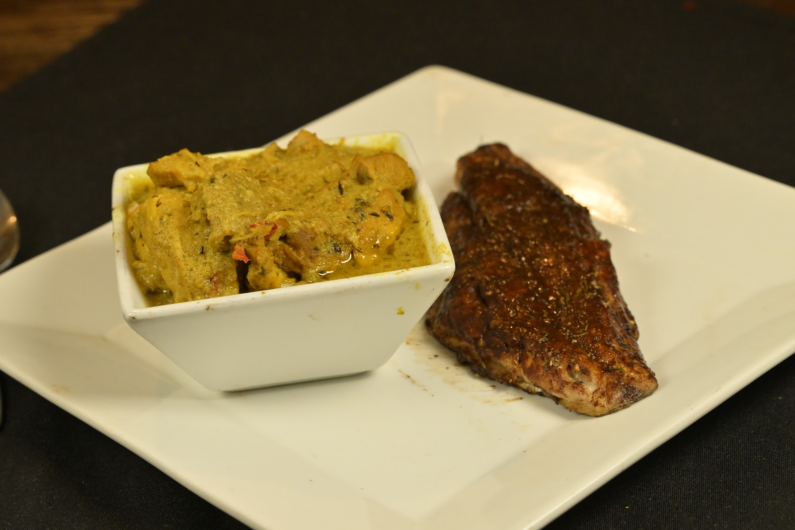 Blackened snapper fillet plated with a curry dish